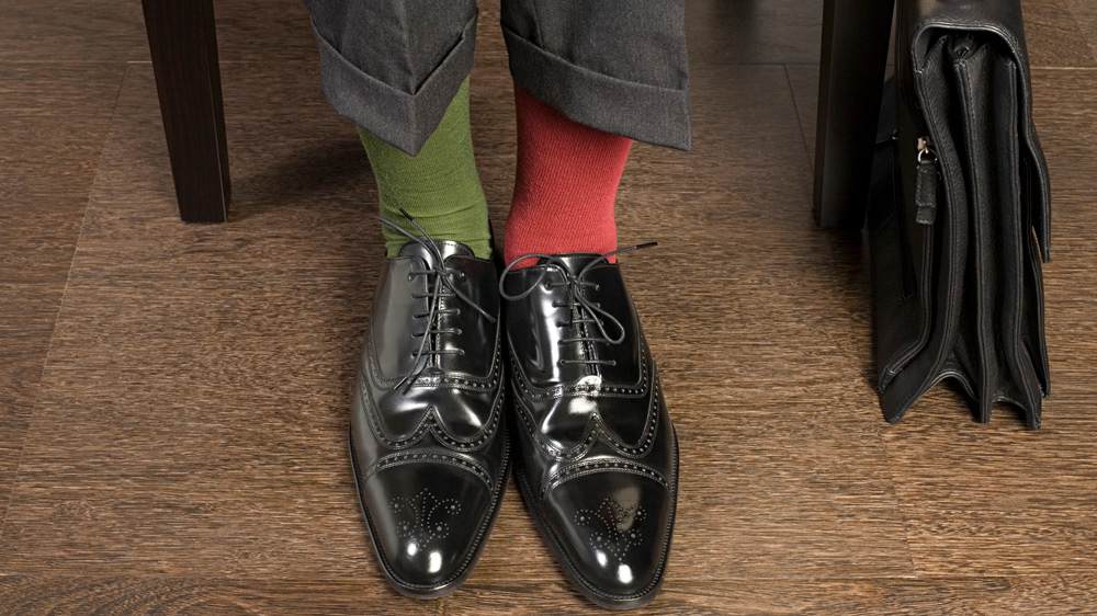 man wearing business slacks and shoes and mismatched socks