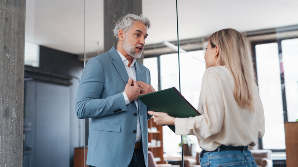 coworker looking defensive in conversation with another