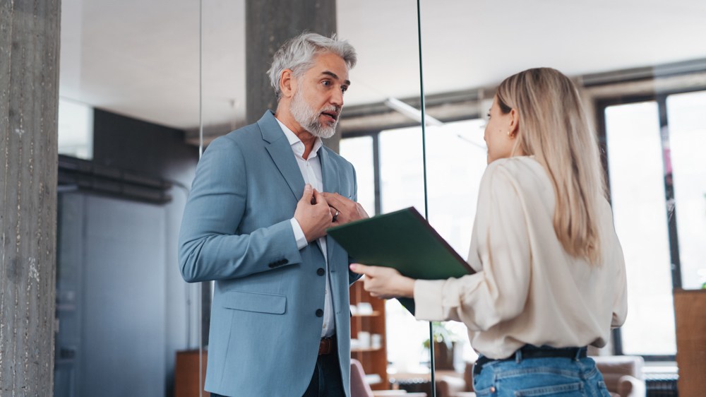 coworker looking defensive in conversation with another