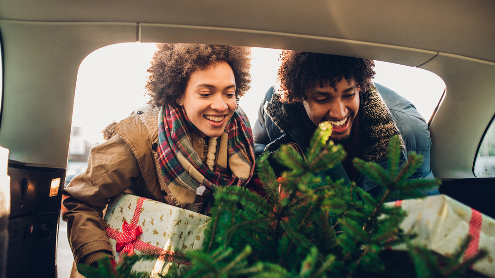young couple putting gifts in the back of car