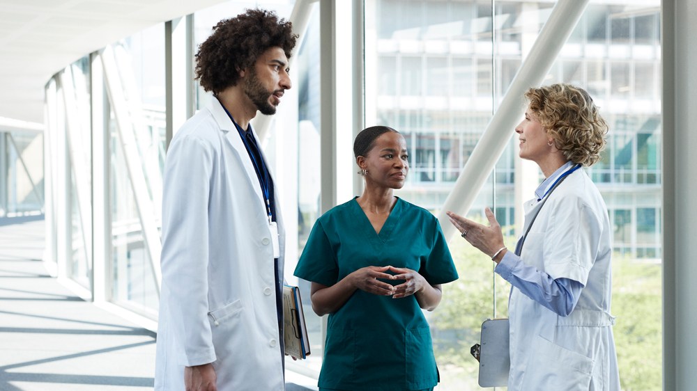 Mature doctor assisting colleagues at hospital