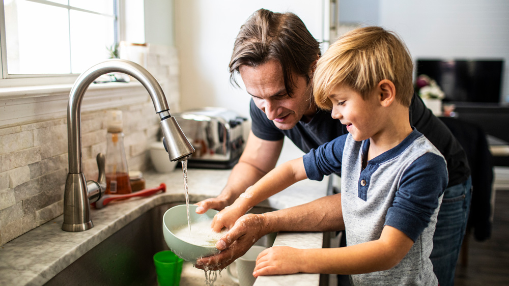 father and son doing dishes in the kitchen