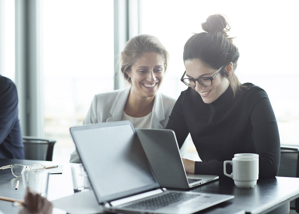 Two women writing grants in workplace