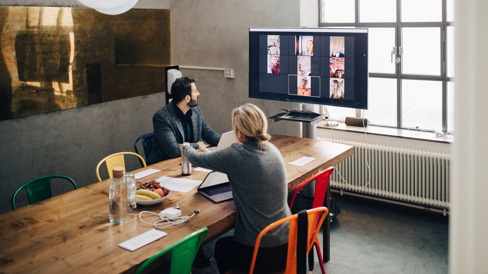 Mature male and female entrepreneurs in video conference with colleagues