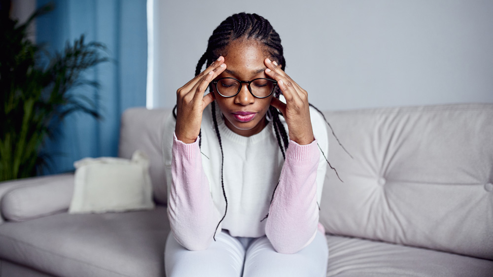 woman sitting on couch feeling stressed