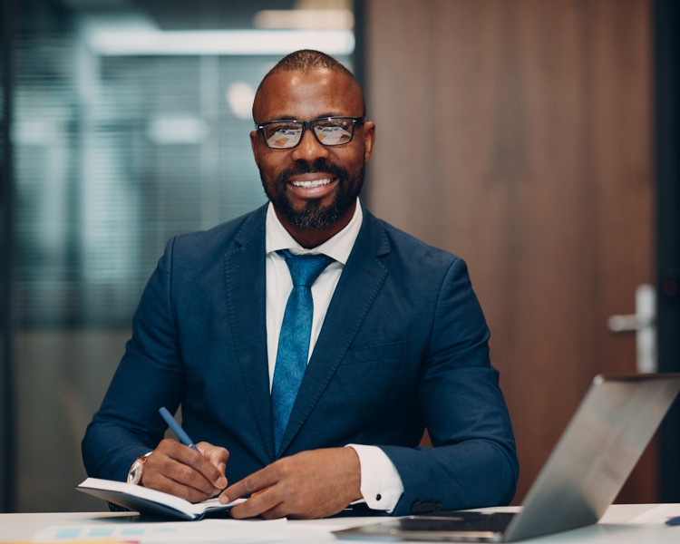 businessman in blue suit sit at table for meeting in office with notebook with pen and laptop.