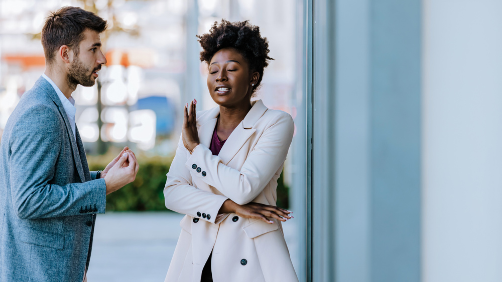 man and woman having a heated conversation on a city sidewalk