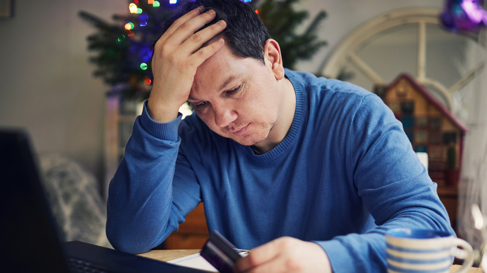 man shopping for christmas online and stressed out