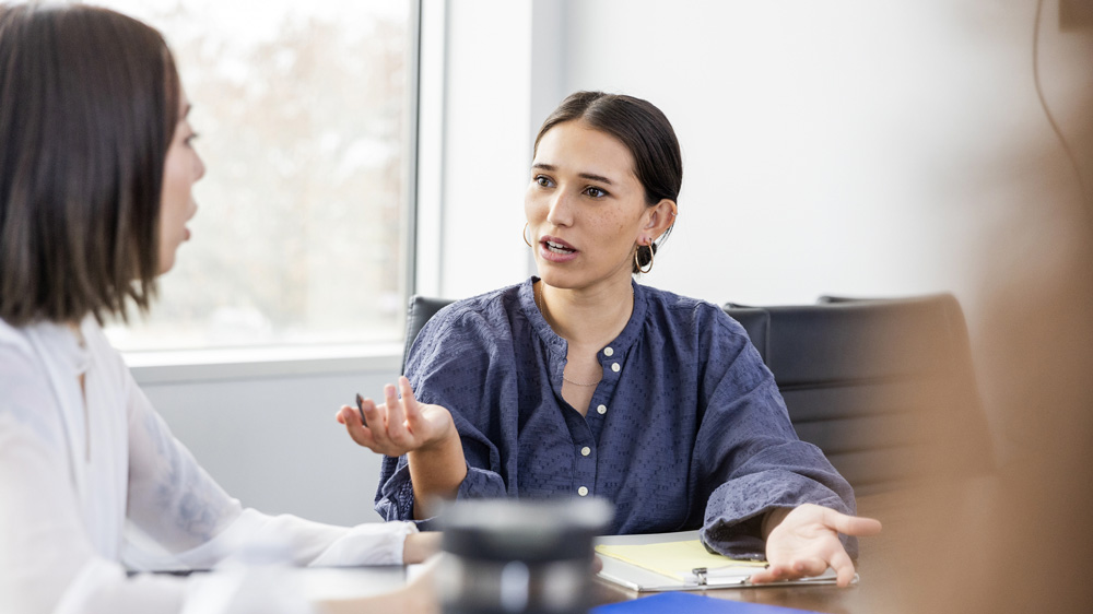 two women talking in business setting