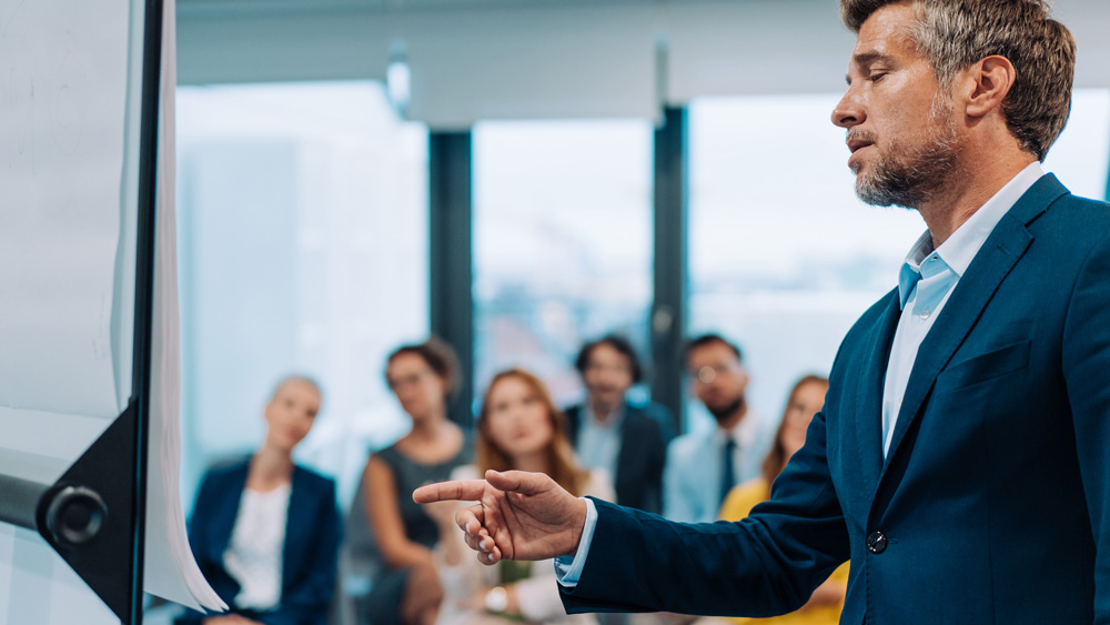 man teaching group in office setting