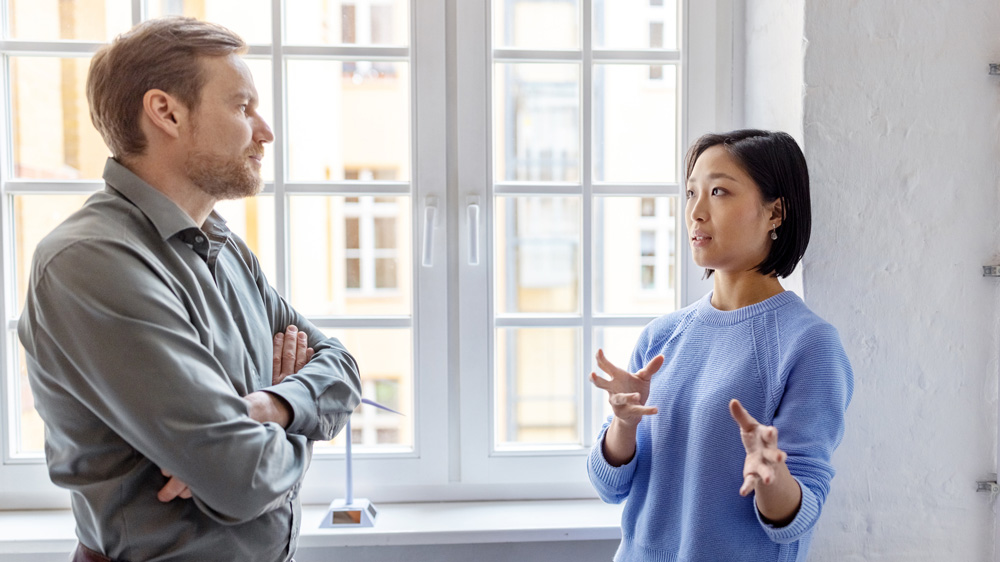 man and woman talking in office with natural light