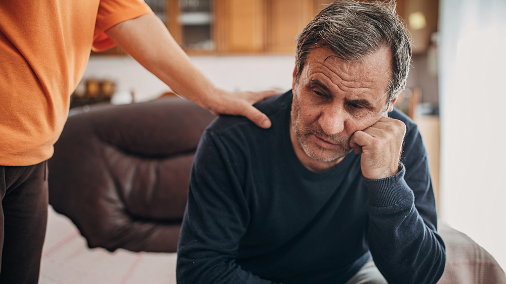 person comforting a depressed man