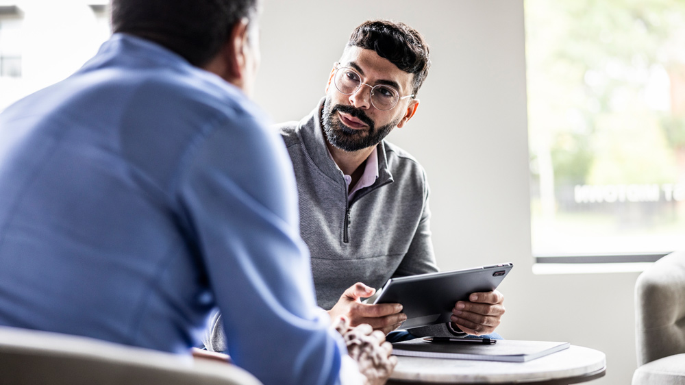 two men talking in business office
