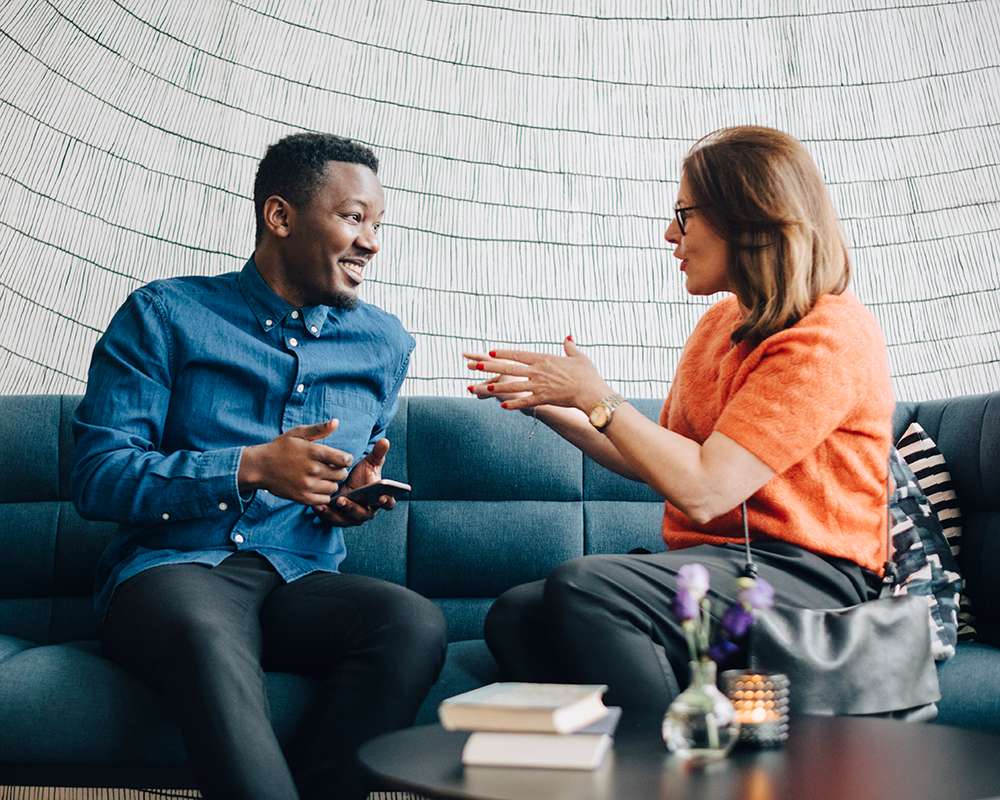 Coworkers having a conversation on a couch