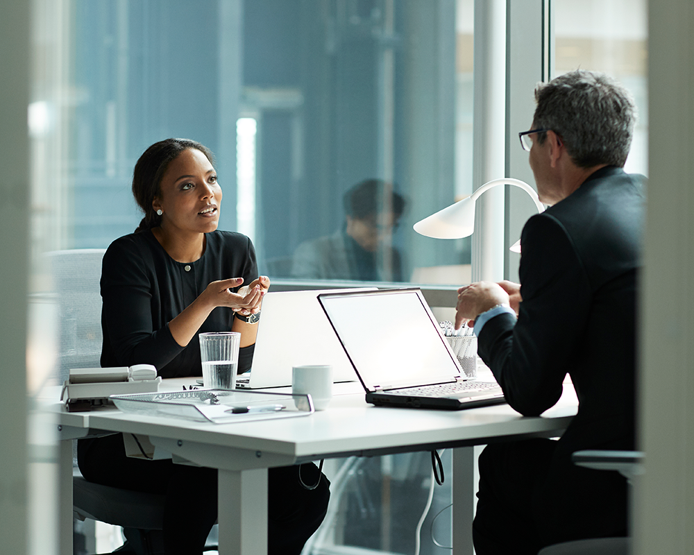 Coworkers having a conversation at a desk